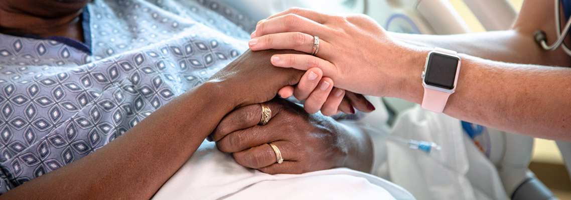 caregiver and patient holding hands